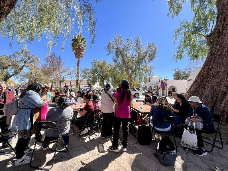 Público participando del taller al aire libre en la plaza de San Pedro de Atacama durante el Festival de la Lana